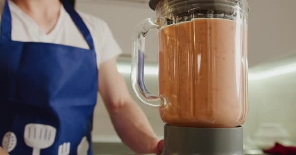 Close-up shooting. The man is starting the blender and mixing the fruit. Making smoothies. 4K - Footage, Video