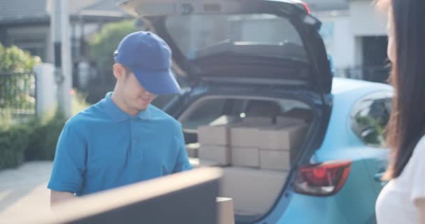 Delivery service male in uniform give cardboard box package to receiver customer client front home, fast express offsite when crisis coronavirus, covid19 new normal lifestyle concept. - Séquence, vidéo