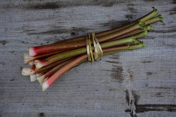 Tiges rouges de la rhubarbe sur un fond naturel. Rhubarbe au début du printemps vitamines et produits diététiques
. - Photo, image