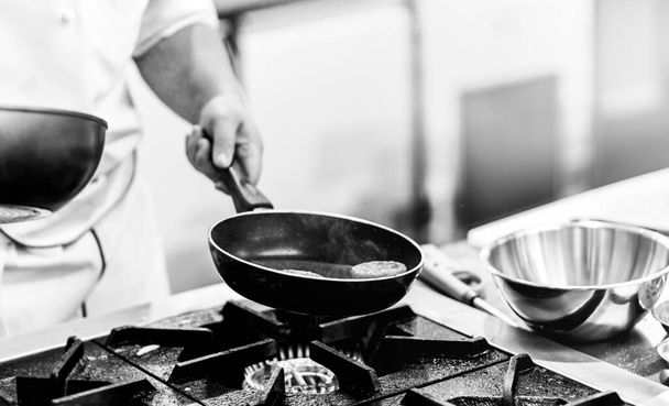 Σεφ μαγείρεμα σε μια κουζίνα, σεφ στη δουλειά, Μαύρο & Γουίτ - Φωτογραφία, εικόνα