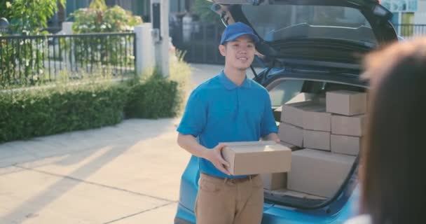 Delivery service male in uniform give cardboard box package to receiver customer client front home, fast express offsite when crisis coronavirus, covid19 new normal lifestyle concept. - Кадри, відео