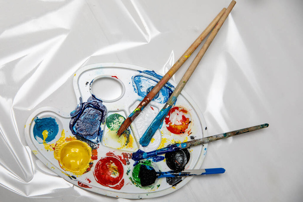 Art palette with tubes of watercolor paints and a brushes. - Photo, Image