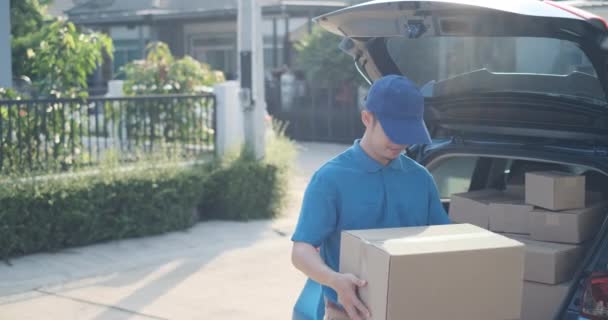 Delivery service male in uniform give cardboard box package to receiver customer client front home, fast express offsite when crisis coronavirus, covid19 new normal lifestyle concept. - Video