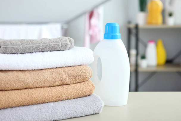 saubere Handtücher und Waschmittel in der Waschküche - Foto, Bild
