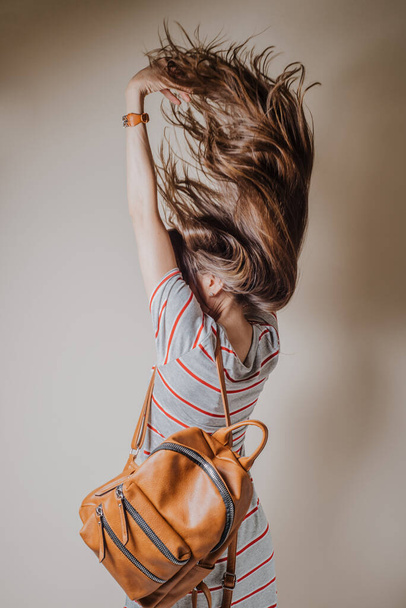 Vista lateral de la mujer saltando con hermoso pelo largo en movimiento
 - Foto, imagen