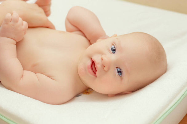 Closeup portrait of beautiful baby boy with blue eyes looking straight in camera - Фото, изображение