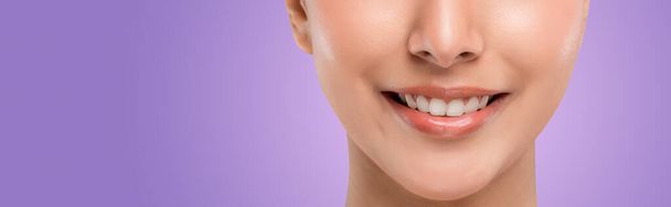 Close up part of the face. The perfect align teeth of young Caucasian teenager woman with smiley face. Isolated on purple background. - Fotografie, Obrázek