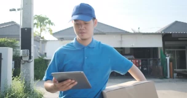 Delivery service male in uniform give cardboard box package walking to receiver customer client front home, fast express offsite when crisis coronavirus, covid19 new normal lifestyle concept. - Felvétel, videó