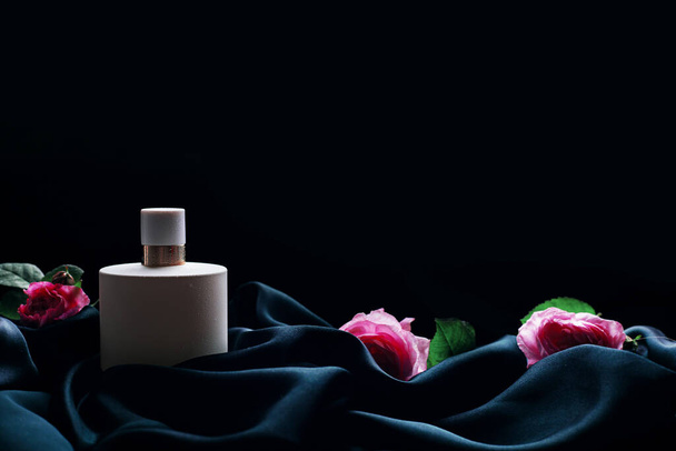 Women's perfume with flowers on a black background - Photo, Image