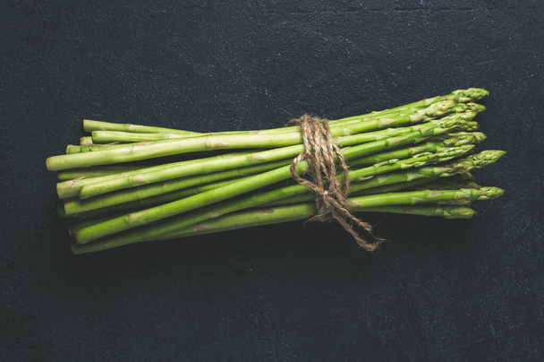 Fresh green asparagus on dark concrete background - Foto, Bild