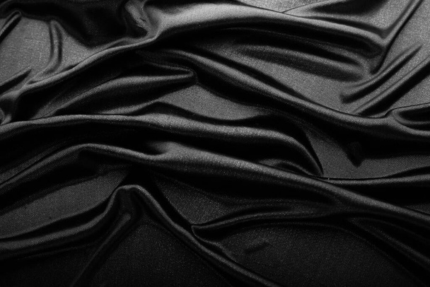 A sima, elegáns fekete selyem vagy szatén textúra elvont háttérként használható. Luxus háttér tervezés - Fotó, kép