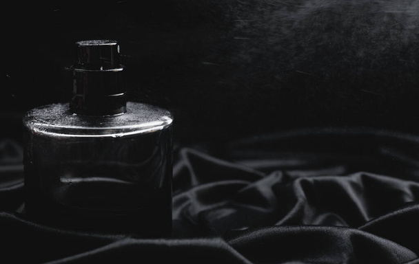 perfume bottle spraying on black background - Valokuva, kuva