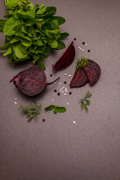 Culinary background. Cooking food concept. Beetroot, fresh mint, dill, sea salt, peppercorn. Trendy black stone concrete backdrop, copy space - Photo, Image