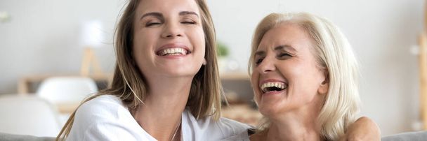 Daughter and aged mother enjoy communication joking having fun indoors - Foto, Imagen