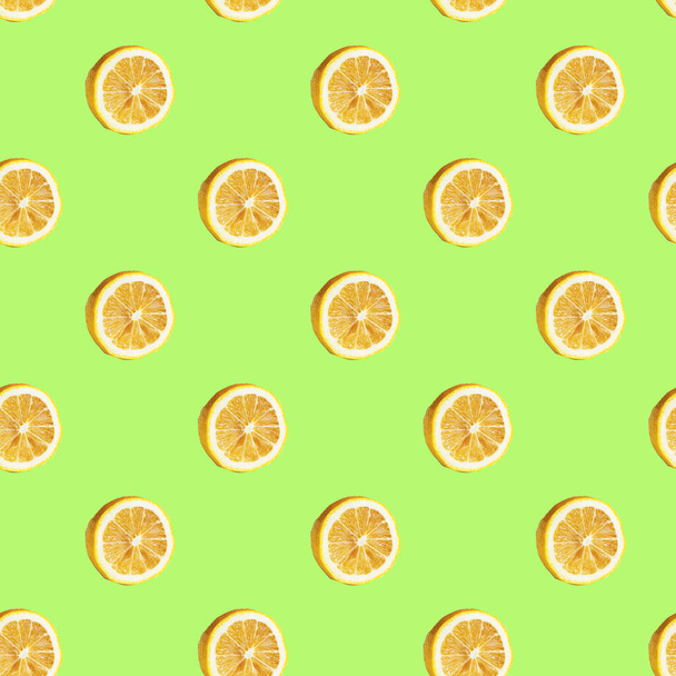 Naadloos patroon met citroenhelften op een groene achtergrond. Minimale isometrische textuur. Gebruik voor schoolborddruk op stof. Uitzicht van bovenaf. - Foto, afbeelding