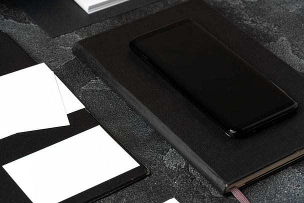 Mock up of blank business card and black smartphone screen on table - Φωτογραφία, εικόνα