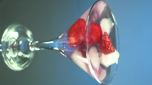 Macro di un barista professionista sta mettendo cubetti di ghiaccio di cristallo professionale in un bicchiere mentre prepara un cocktail alcolico ai clienti del bar o discoteca. Video verticale per smartphone e tablet - Filmati, video
