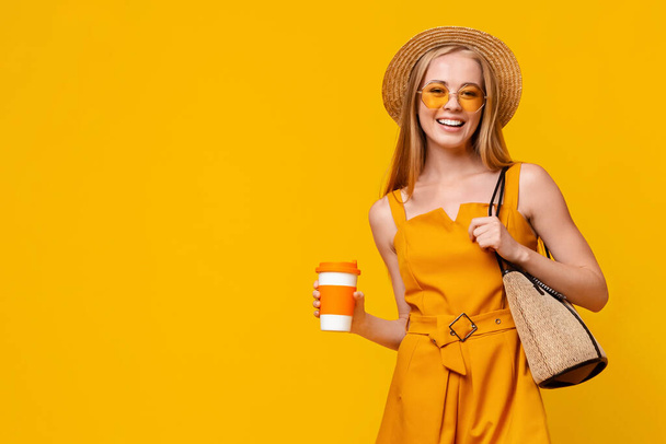 Positive Teen Girl Holding Cup mit Takeaway Drink und Lächeln in die Kamera - Foto, Bild