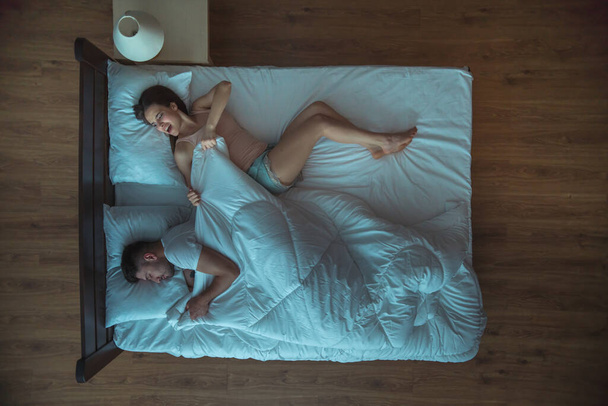 Жінка тягне ковдру на ліжко. вечірній нічний час. вид зверху
 - Фото, зображення
