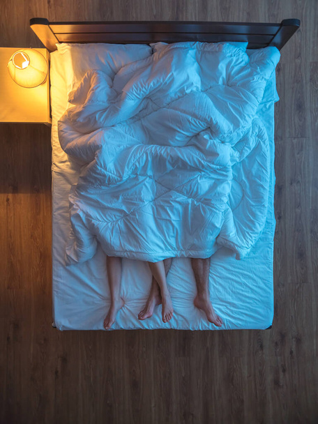 La pareja estaba a cubierto en la cama. noche de noche. vista desde arriba
 - Foto, Imagen