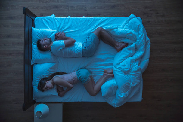 The man and woman sleeping on the bed. evening night time. view from above - Foto, afbeelding