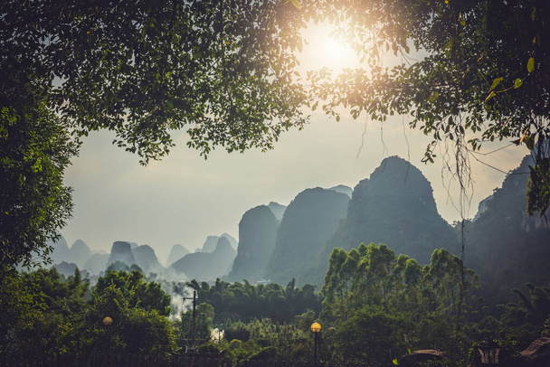 Чудовий карстовий гірський ландшафт Яншуо перед сутінками в сонячний спекотний літній день, провінція Гуансі (Китай). - Фото, зображення