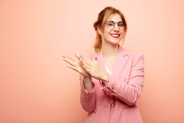 young pretty blonde woman feeling happy and successful, smiling and clapping hands, saying congratulations with an applause. business concept - Fotó, kép