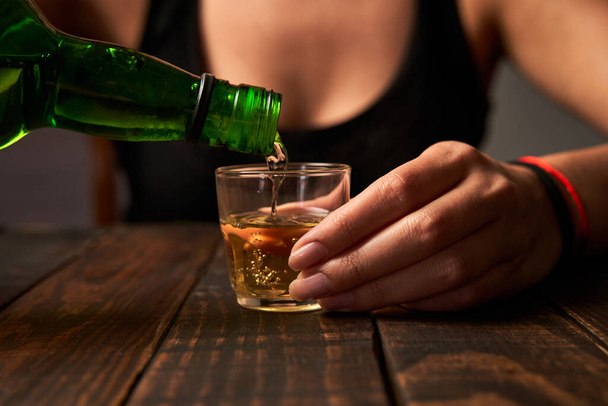 Mujer en un bar vertiendo alcohol en un vaso de chupito
. - Foto, imagen