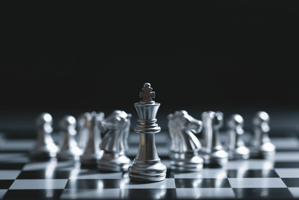 Koning van de strijd schaken spel staan op schaakbord met zwarte geïsoleerde achtergrond. Bedrijfsleiderschapsconcept. - Foto, afbeelding