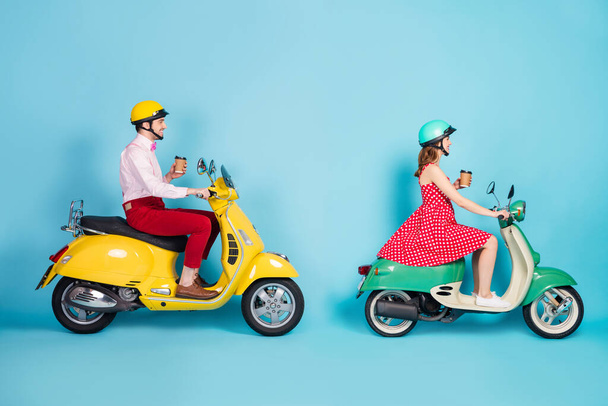 Full size profile photo of funny lady guy couple drive retro moped travelers drink takeaway coffee traffic jam good mood not rush vintage outfit protective cap isolated blue color background - Foto, Bild
