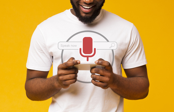 Африканский парень с помощью голосового поиска на смартфоне
 - Фото, изображение