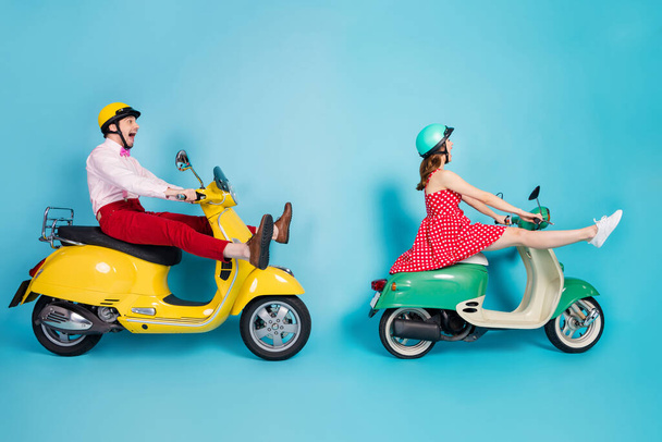 Full length profile photo of crazy lady guy couple drive two retro moped travelers traffic jam easy way spread legs rejoicing having fun vintage clothes caps isolated blue color background - Foto, Bild