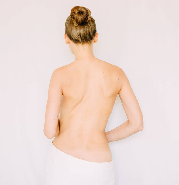 Πίσω όψη της γυναίκας φορώντας πετσέτα, Όμορφη νεαρή γυναίκα προετοιμάσει το σώμα της για το ντους, spa ή μασάζ - Φωτογραφία, εικόνα