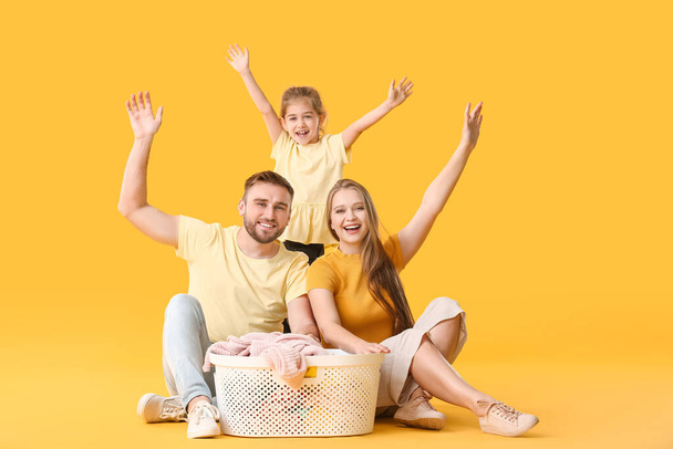 Happy family with laundry on color background - Foto, Imagem