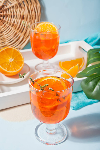 Glasses with fresh homemade orange sweet iced tea or cocktail, lemonade with thyme. Refreshing cold drink. Summer party or picnic. - Foto, imagen