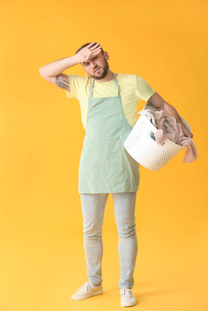 Troubled man with laundry on color background - Zdjęcie, obraz