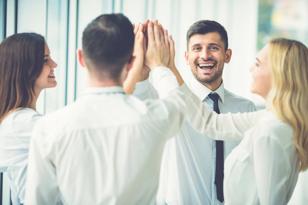 Счастливые деловые люди приветствуют с "дай пять"
 - Фото, изображение
