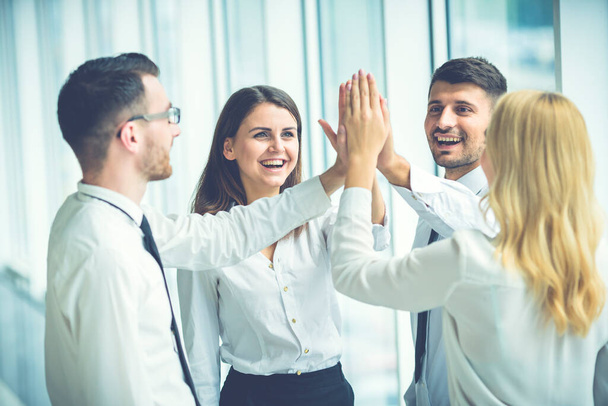 The four business people greeting with a high five - Photo, Image