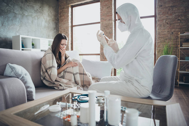 Photo of sick patient lady unwell call emergency doc virologist flu cold covid injection immunization medical help covered plaid blanket coughing wear gloves protective uniform indoors - Foto, Imagen