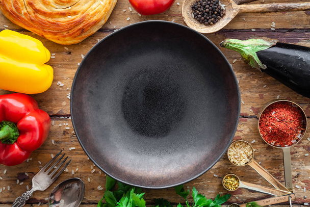 Ingrédients Pilaf, riz, légumes, pita, couverts, épices sur fond rustique - Photo, image