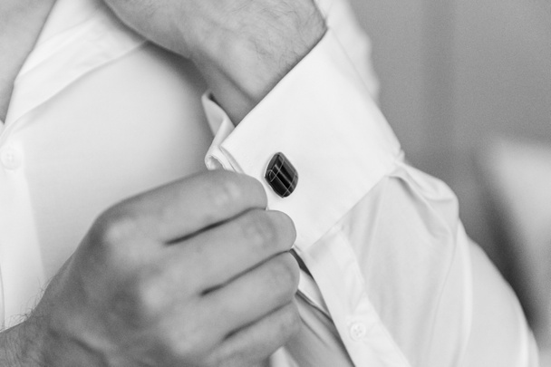 close-up van een hand man draagt wit shirt en manchetknoop - Foto, afbeelding