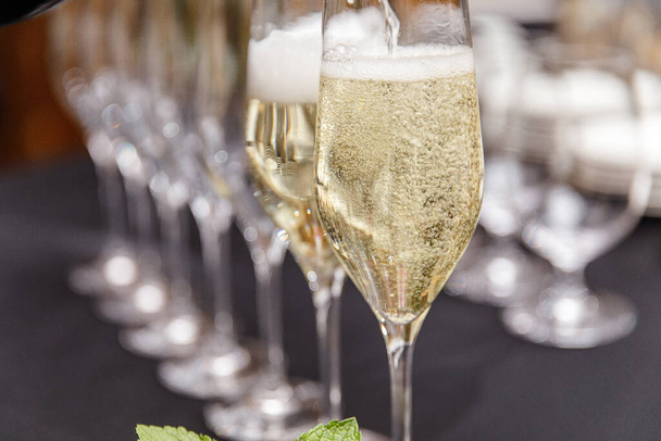 Verre de champagne dans les mains d'une fille à la table festive
 - Photo, image