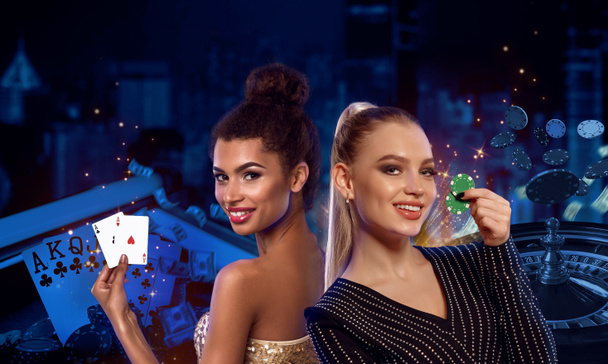 Young models are smiling, showing two green chips and aces. Posing on colorful background with roulette and flying chips. Poker, casino. Close-up - Photo, Image