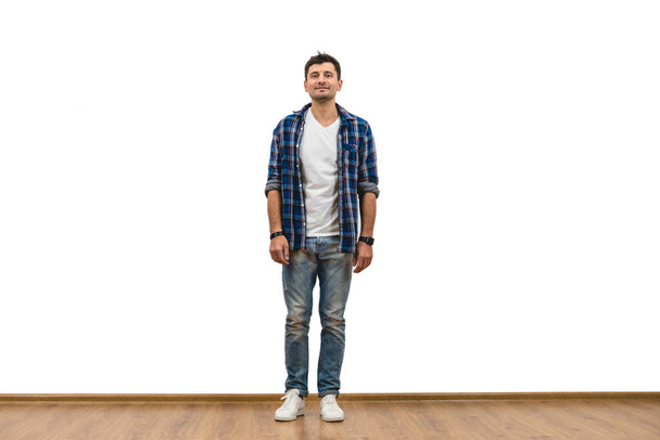 The man standing on the white wall background - Фото, изображение