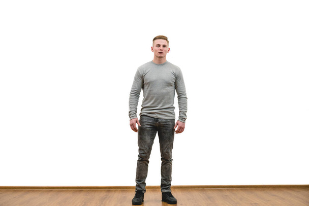 Чоловік стоїть на фоні білої стіни
 - Фото, зображення