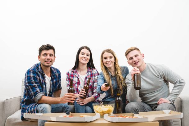 Четверо людей дивляться телевізор з піцою і пивом на білому тлі
 - Фото, зображення