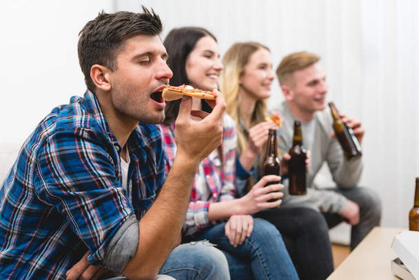 Čtyři lidé na pohovce jíst pizzu a pít pivo na bílém pozadí - Fotografie, Obrázek