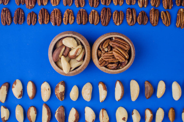 青を基調としたピーカンナッツとブラジルナッツ。健康食品 - 写真・画像