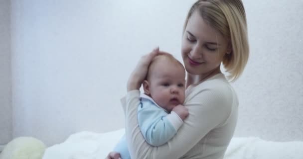 Happy mother holds her baby, hugging and kissing. - Video