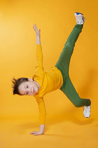  boy stand on hands on a yellow background - 写真・画像